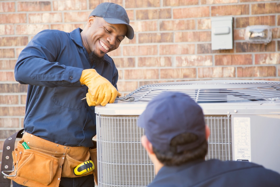 HVAC technician servicing outdoor air conditioning unit